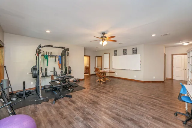 a view of a room with gym equipment and wooden floor
