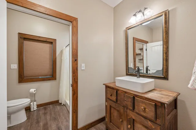 a bathroom with a toilet a sink a vanity and mirror