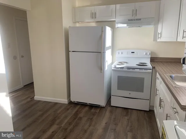 a kitchen with a stove top oven and refrigerator
