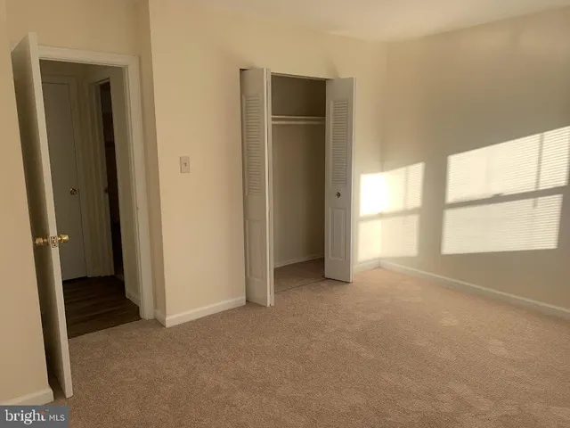 an empty room with windows and closet