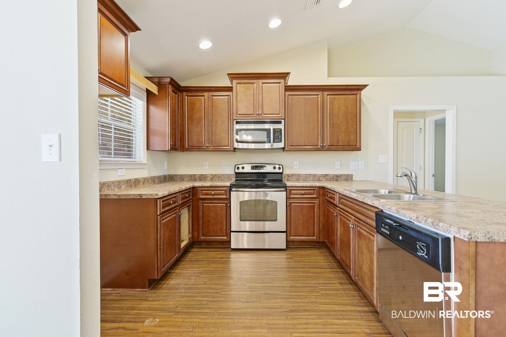 11153 Sturbridge Loop Daphne, AL 36526 - Photo 30 of 79 Kitchen featuring sink, stainless steel appliances, kitchen peninsula, light hardwood / wood-style floors, and vaulted ceiling