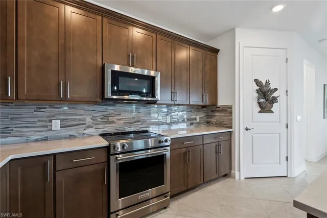 a kitchen with stainless steel appliances granite countertop a stove microwave and cabinets