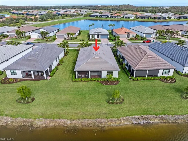 an aerial view of a house with a garden and lake view