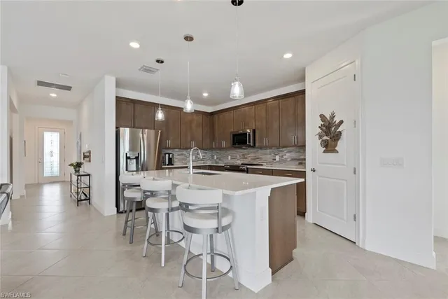 a kitchen with stainless steel appliances kitchen island granite countertop a refrigerator and a stove top oven