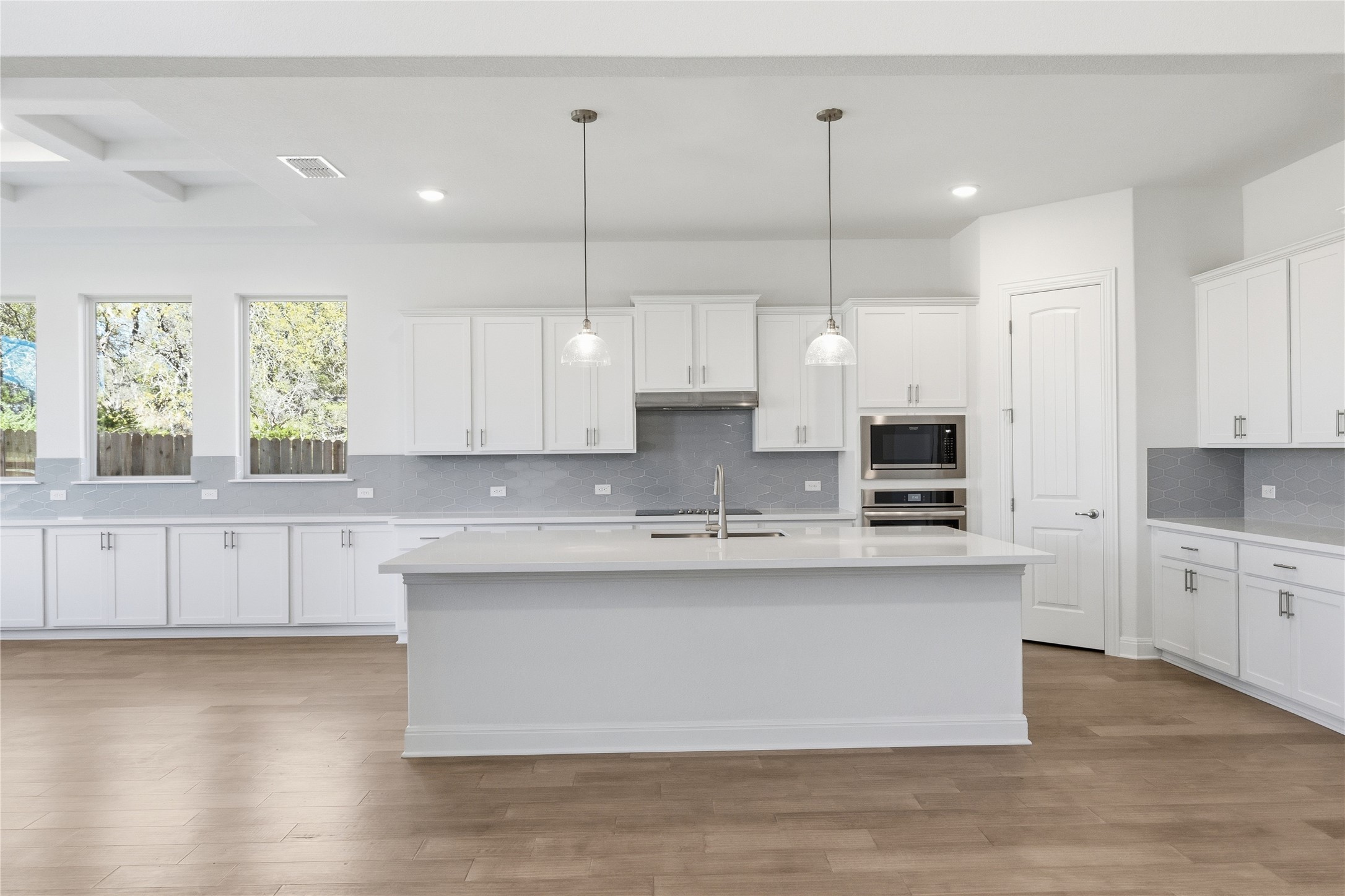 308 Frio Spgs Trail Georgetown, TX 78628 - Photo 8 of 32 a large kitchen with white cabinets and wooden floor
