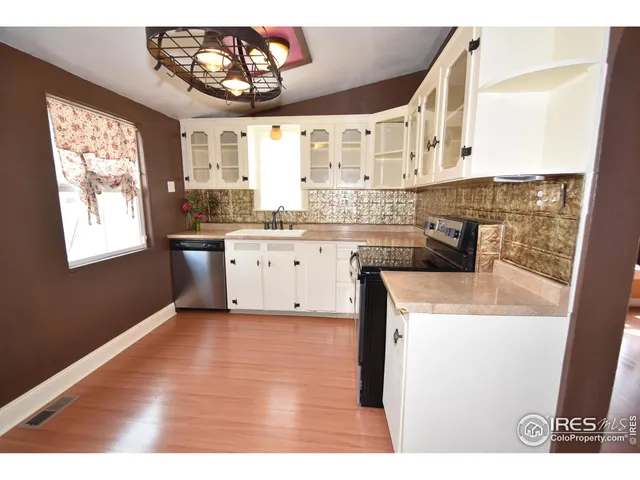 a view of kitchen with wooden floor and electronic appliances