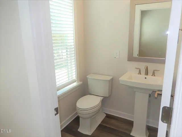 a bathroom with a toilet a sink and a window