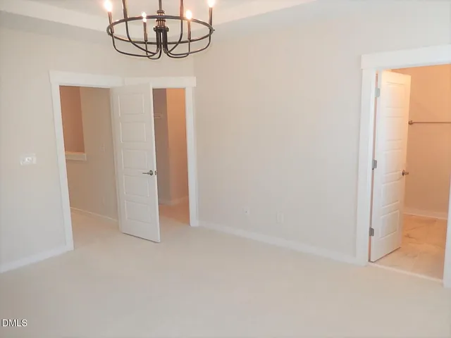 an empty room with chandelier fan