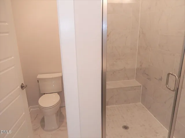 a bathroom with a toilet and a shower