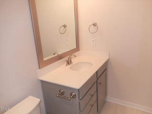 a bathroom with a sink and mirror with toilet