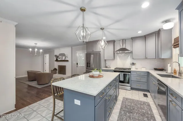 a kitchen with stainless steel appliances granite countertop a sink a stove and a refrigerator