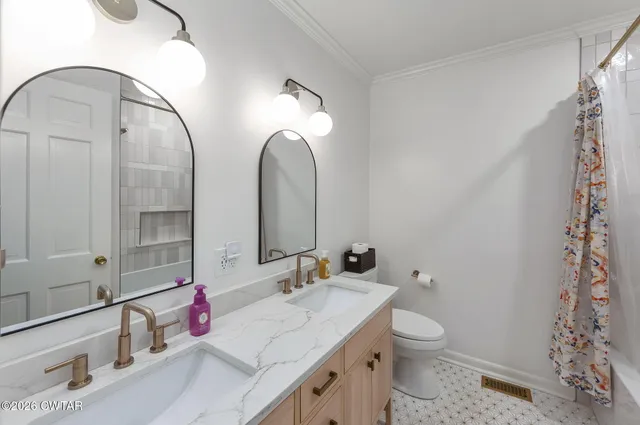 a bathroom with a granite countertop sink mirror and toilet