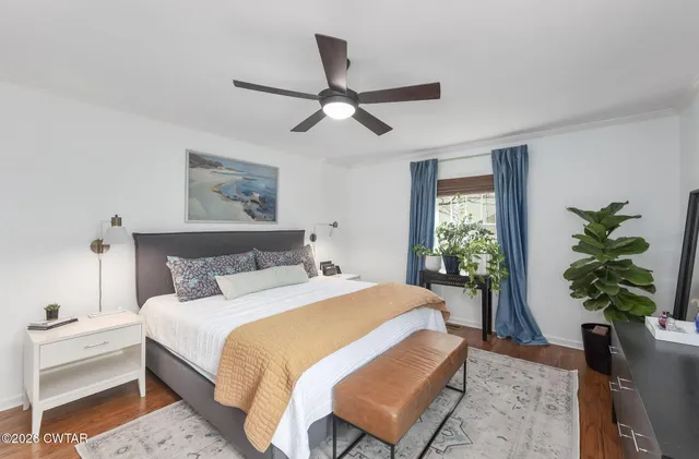 a bedroom with a large bed and a potted plant