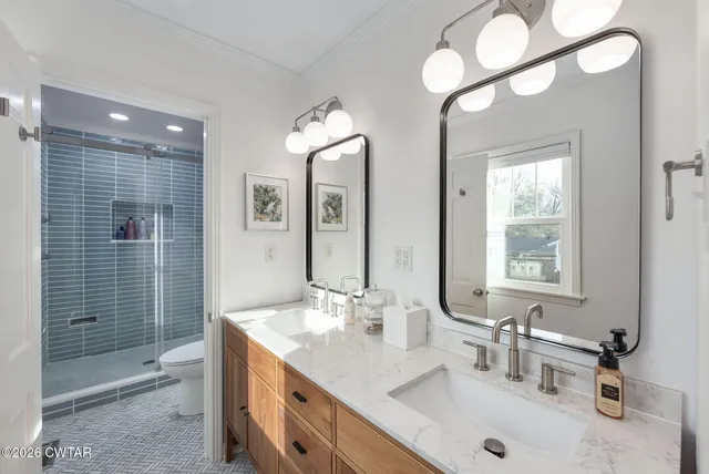 a bathroom with a double vanity sink mirror and shower