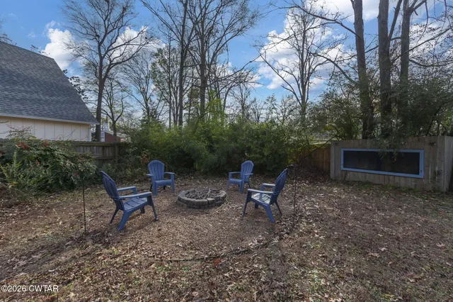 a view of backyard with outdoor seating and trees