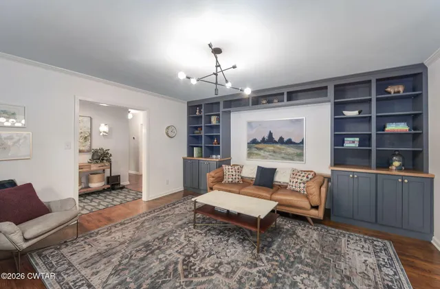 a living room with furniture and a chandelier