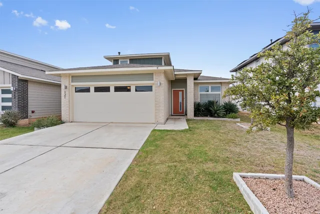 a view of a white house with a yard