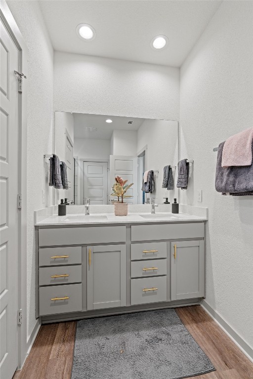 121 Tequilana Pass Leander, TX 78641 - Photo 17 of 39 Bathroom with double vanity, light wood-style flooring, recessed lighting, and a textured wall