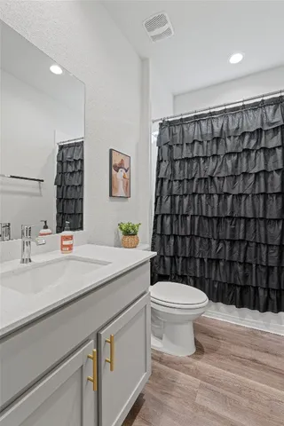 a bedroom with a flat screen tv on the dresser and a flat screen tv