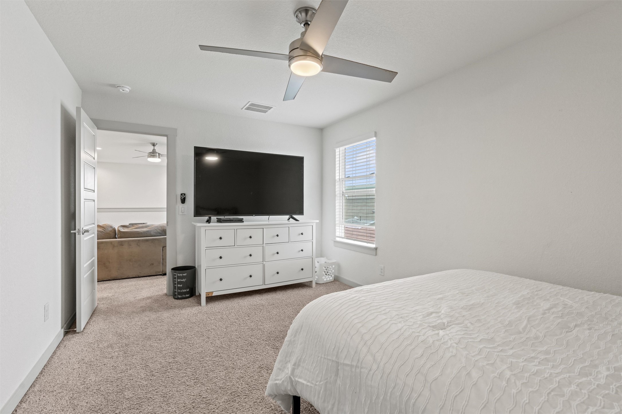 121 Tequilana Pass Leander, TX 78641 - Photo 31 of 39 a bedroom with a flat screen tv on dresser and a chandelier