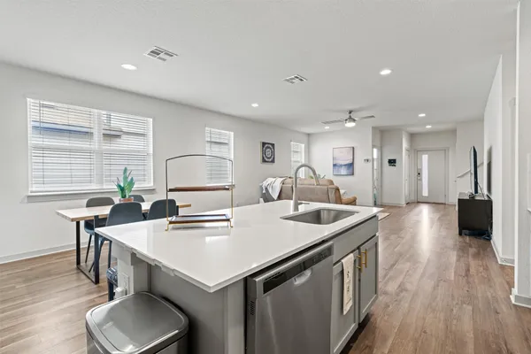 a kitchen with a sink a stove and wooden floor