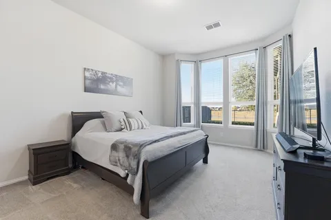 a spacious bedroom with a bed and a large window