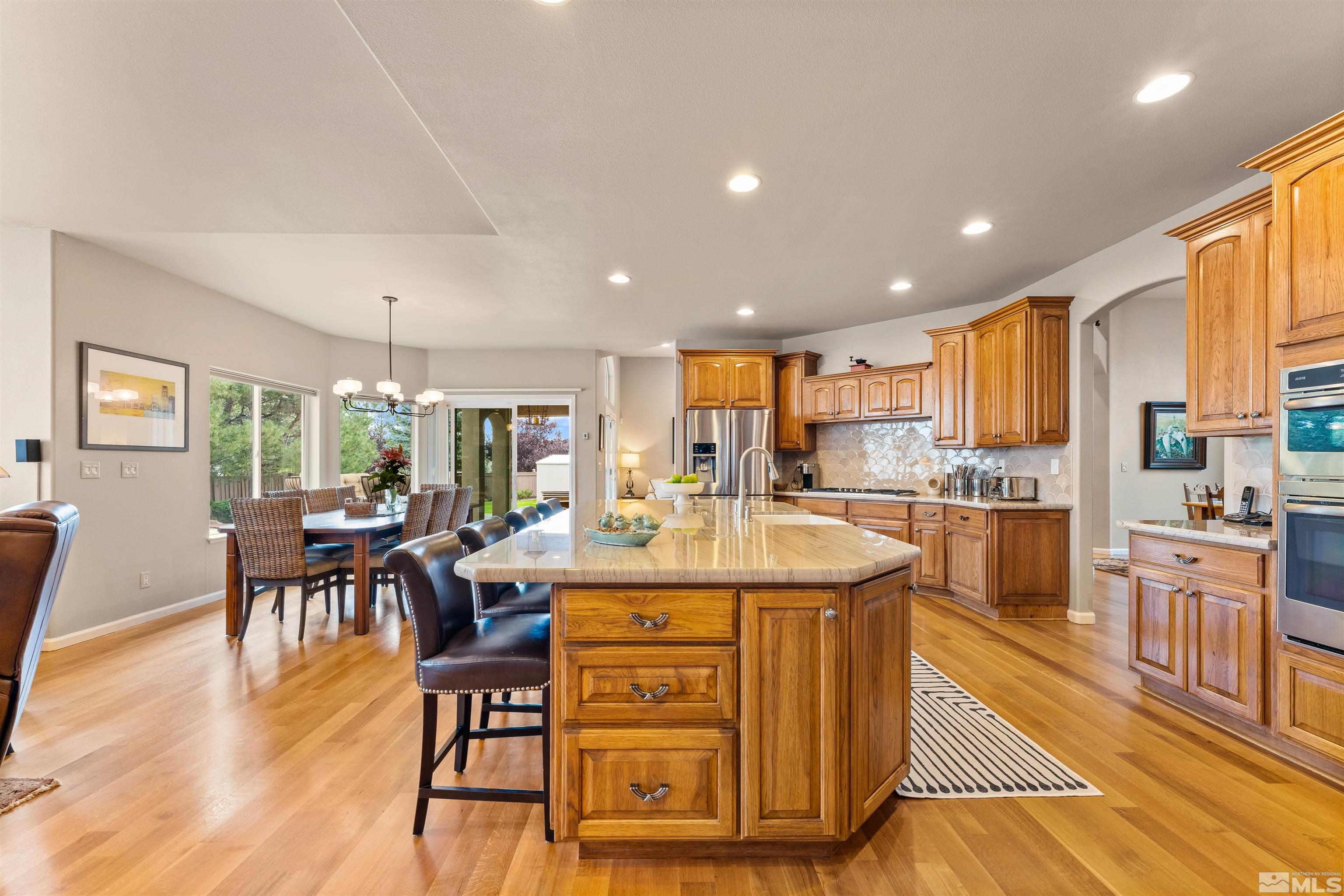 12875 Welcome Way Reno, NV 89511 - Photo 9 of 39 a large kitchen with kitchen island a large island a stove a table and chairs in it
