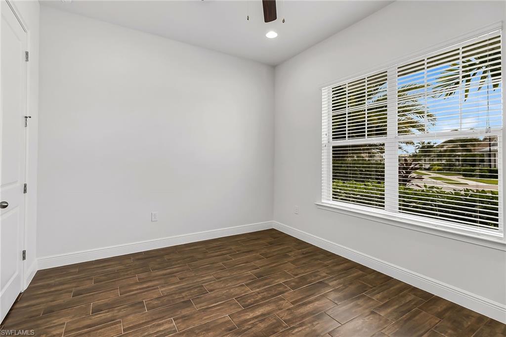 3668 Pilot Circle Naples, FL 34120 - Photo 13 of 29 a view of an empty room with wooden floor and a window