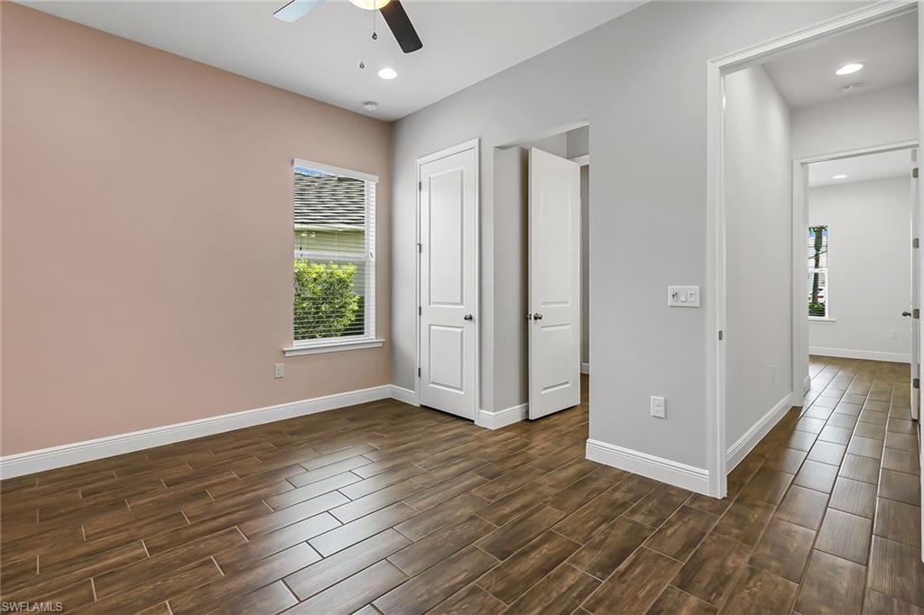 3668 Pilot Circle Naples, FL 34120 - Photo 16 of 29 an empty room with wooden floor cabinet and windows