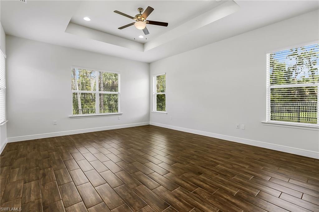 3668 Pilot Circle Naples, FL 34120 - Photo 17 of 29 a view of an empty room with wooden floor and a window