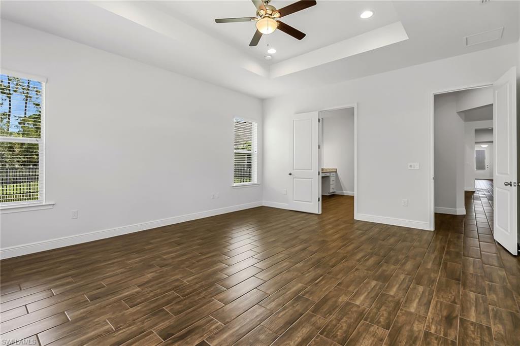 3668 Pilot Circle Naples, FL 34120 - Photo 18 of 29 an empty room with wooden floor and windows