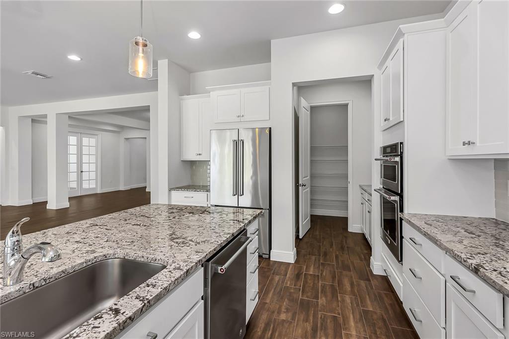 3668 Pilot Circle Naples, FL 34120 - Photo 7 of 29 a kitchen with stainless steel appliances granite countertop a refrigerator and a sink