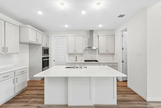 a large kitchen with kitchen island a sink stainless steel appliances and cabinets