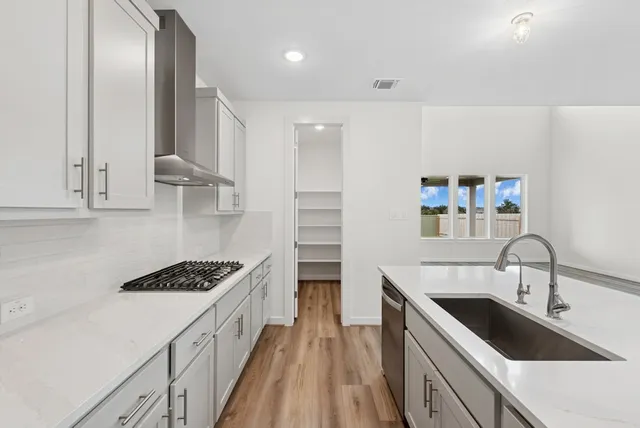 a kitchen with kitchen island stainless steel appliances a sink stove and cabinets