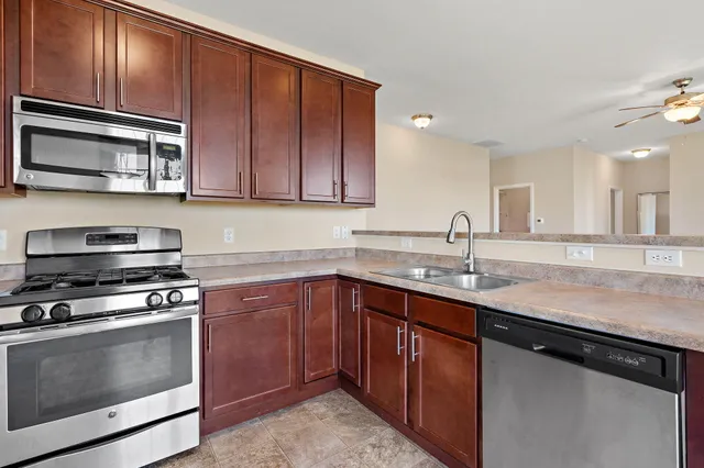 a kitchen with stainless steel appliances granite countertop a sink stove and microwave