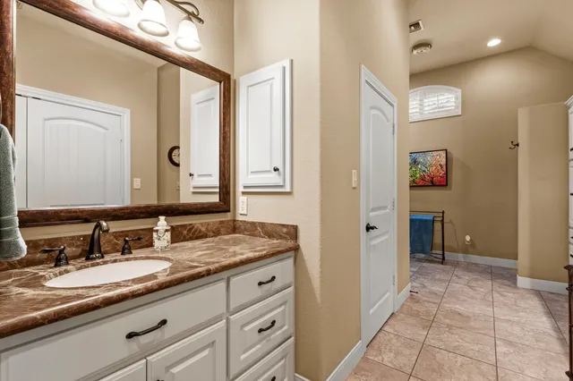 a bathroom with a granite countertop sink and a mirror