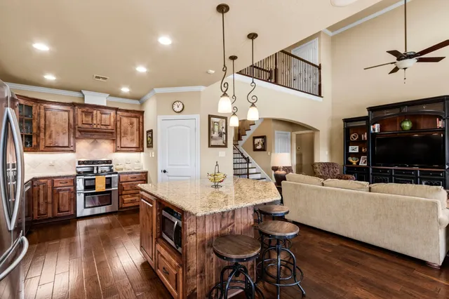 a living room with stainless steel appliances furniture and a flat screen tv