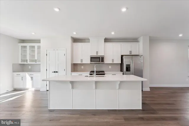 a kitchen with stainless steel appliances a refrigerator and a stove top oven