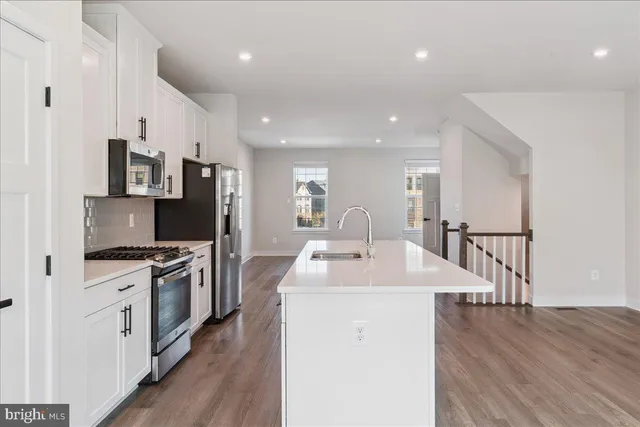 a kitchen with stainless steel appliances kitchen island granite countertop a stove a sink a refrigerator and a microwave