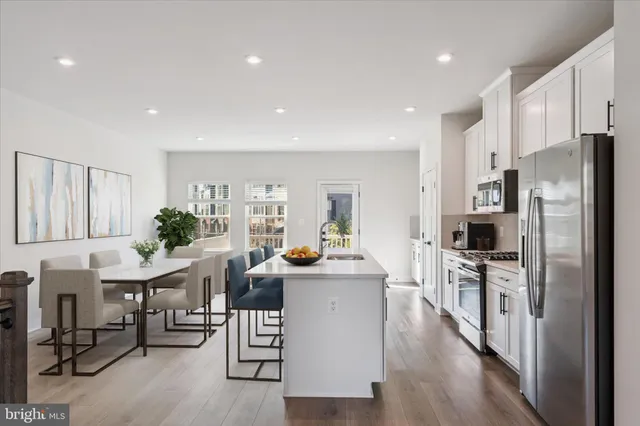 a kitchen with a table chairs refrigerator and microwave