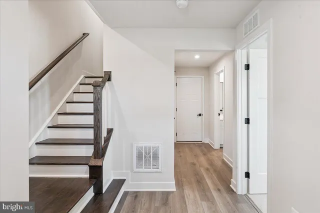 a view of a hallway with wooden floor and entryway