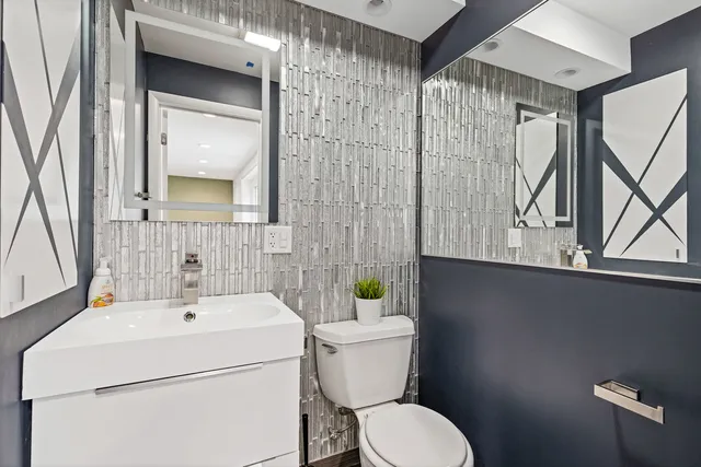 a bathroom with a toilet sink and mirror