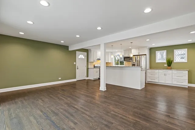 a view of a kitchen with a sink wooden cabinets and a window