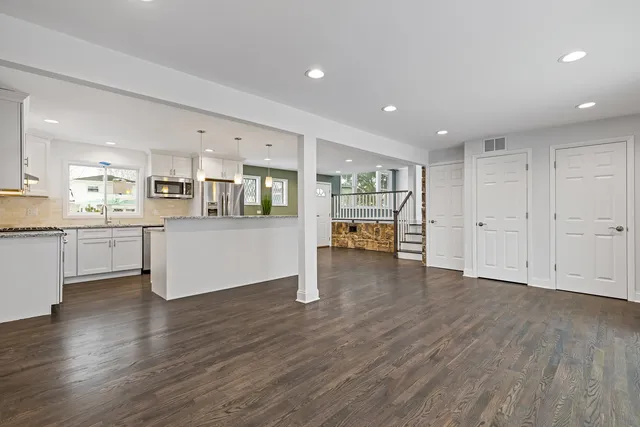 a view of a kitchen with wooden floor and a window