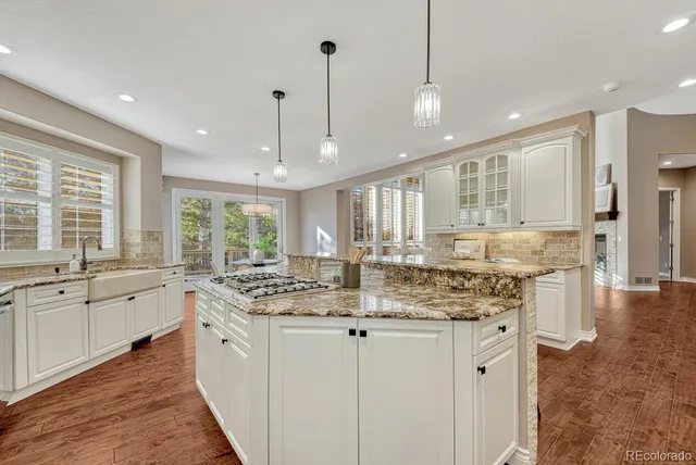 a kitchen with stainless steel appliances granite countertop stove a sink a center island and windows