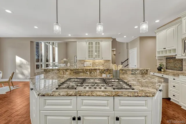 a view of a kitchen with kitchen island granite countertop wooden floor and a counter top space