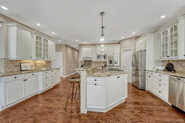 a large kitchen with stainless steel appliances granite countertop a stove a sink dishwasher and a refrigerator
