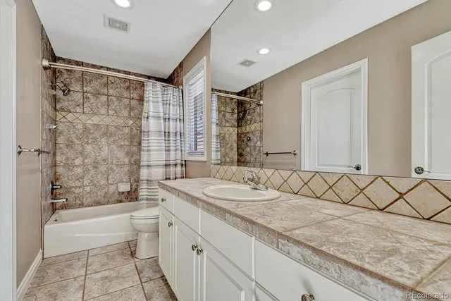 a bathroom with a granite countertop sink and a mirror a bathtub