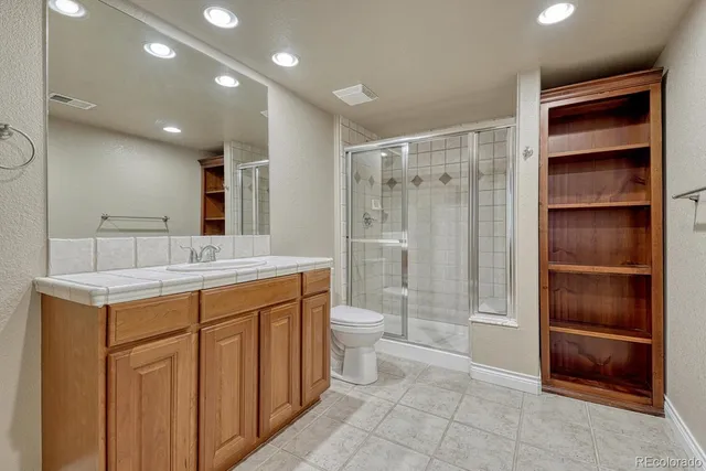 a bathroom with a double vanity sink toilet and shower