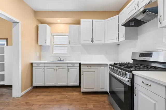 a kitchen with white cabinets and appliances